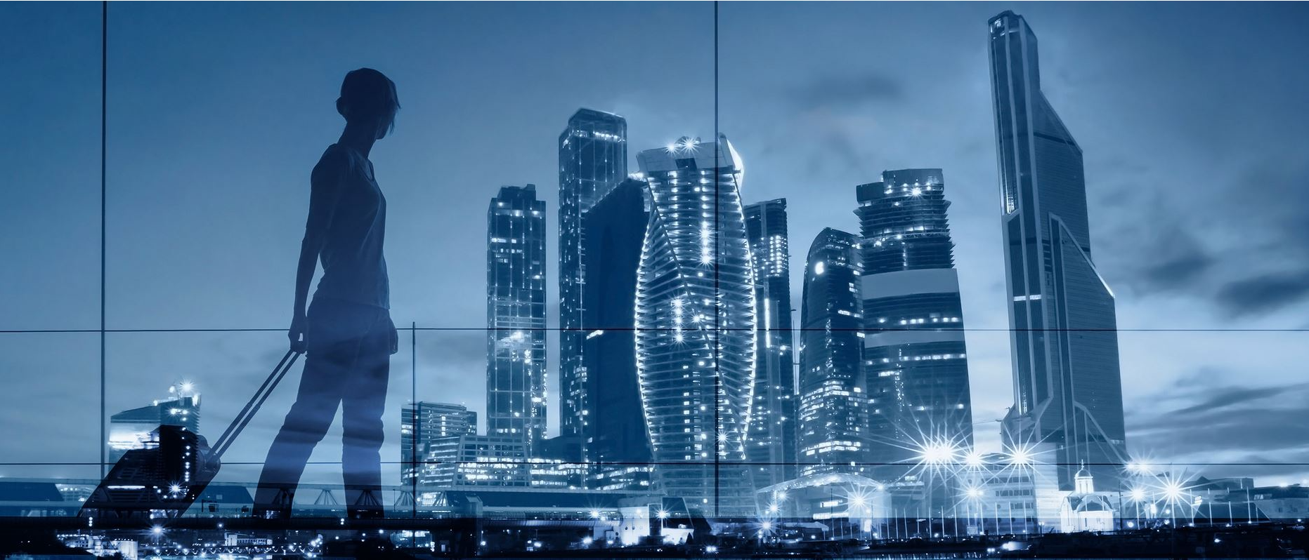 Geschäftsreisende vor nächtlicher Skyline